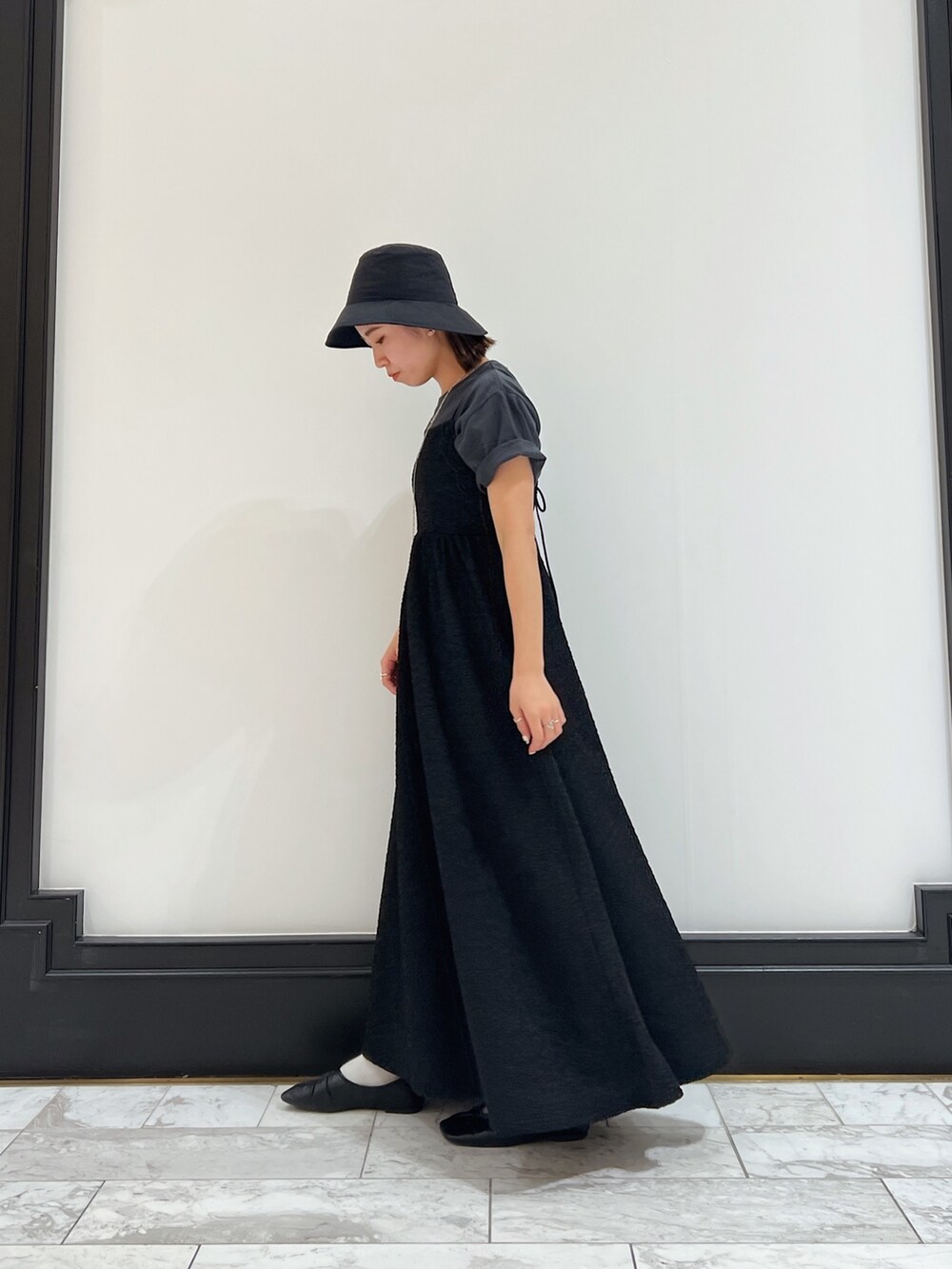 ブラック系のワンピース、グレー系のTシャツ/カットソー、ブラック系のパンプスを着用したレディースの春コーディネートの6枚目の写真