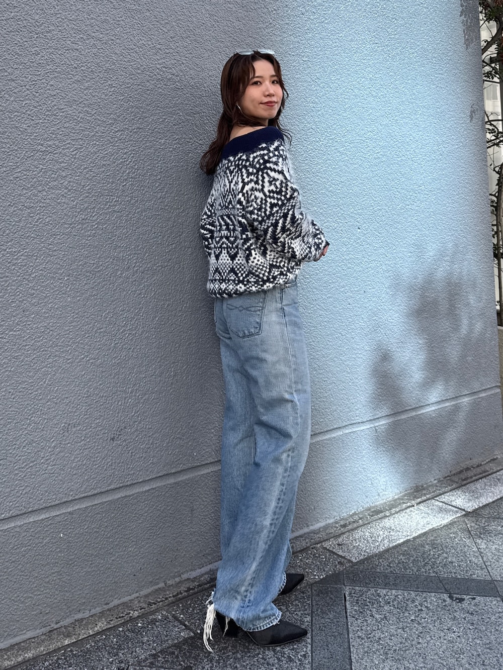 ブルー系のニット/セーター、ブルー系のデニムパンツを着用したレディースの秋コーディネートの3枚目の写真