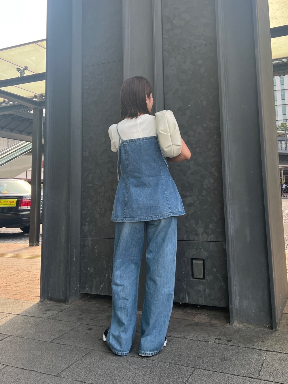 ブルー系のデニムパンツ、ホワイト系のTシャツ/カットソー、ブルー系のキャミソールを着用したレディースの春コーディネートの2枚目の写真