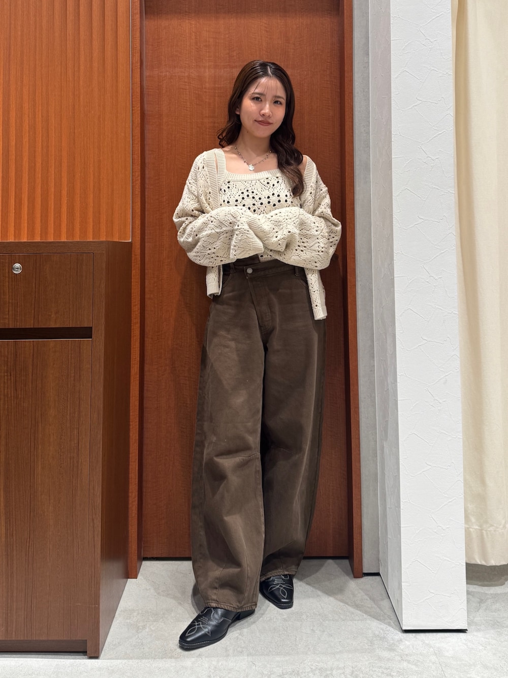 ブラウン系のデニムパンツ、ホワイト系のアンサンブル、ブラック系のその他シューズを着用したレディースの秋コーディネートの7枚目の写真