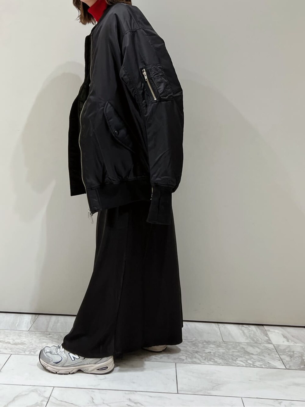 ブラック系のスカート、ブラック系のMA-1、レッド系のニット/セーターを着用したレディースの秋コーディネートの4枚目の写真