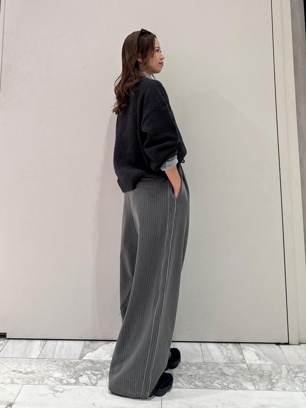 グレー系のその他パンツ、グレー系のニット/セーター、ブルー系のTシャツ/カットソーを着用したレディースの冬コーディネートの3枚目の写真