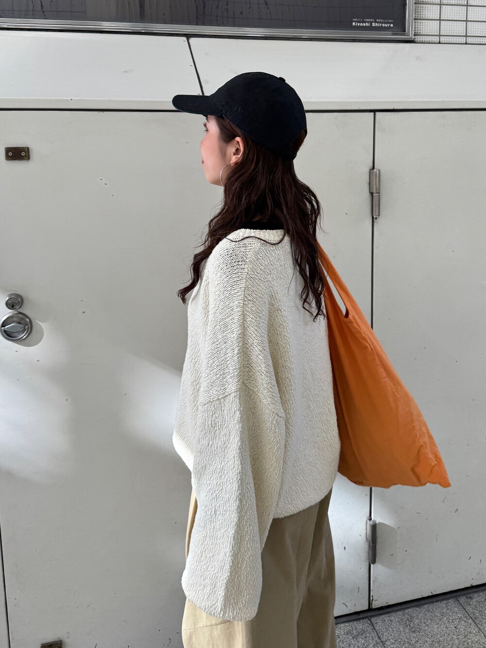 ベージュ系のチノパンツ、ホワイト系のニット/セーター、オレンジ系のエコバッグ/サブバッグを着用したレディースの冬コーディネートの10枚目の写真