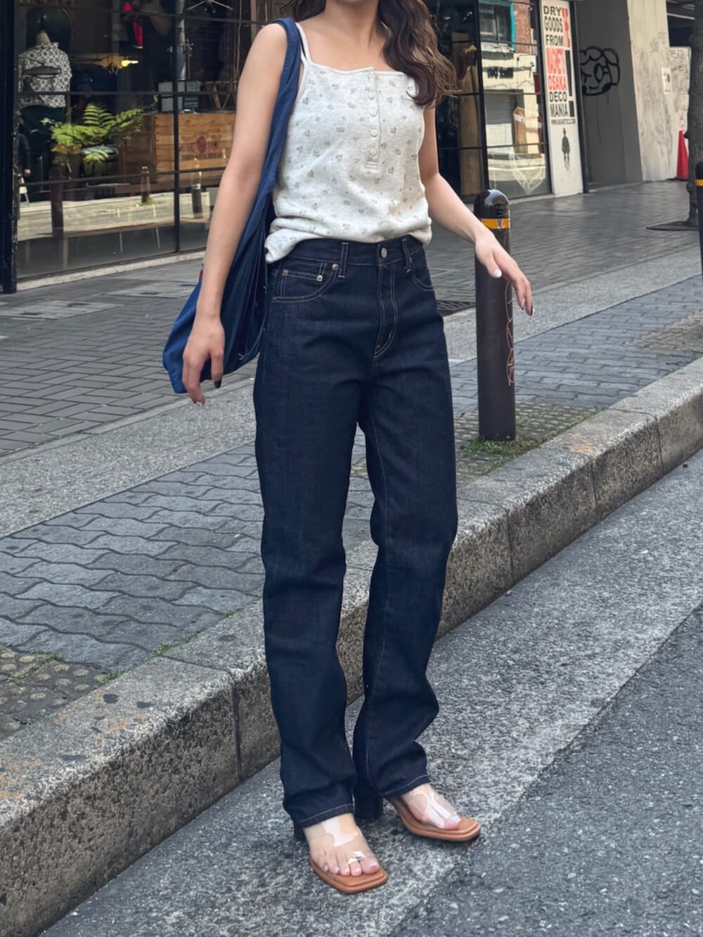 ブルー系のデニムパンツ、その他のサンダル、ブルー系のトートバッグを着用したレディースの春コーディネートの2枚目の写真