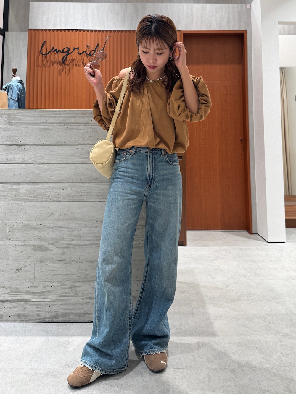 ブルー系のデニムパンツ、イエロー系のシャツ/ブラウス、ブラウン系のサングラスを着用したレディースの夏コーディネートの7枚目の写真