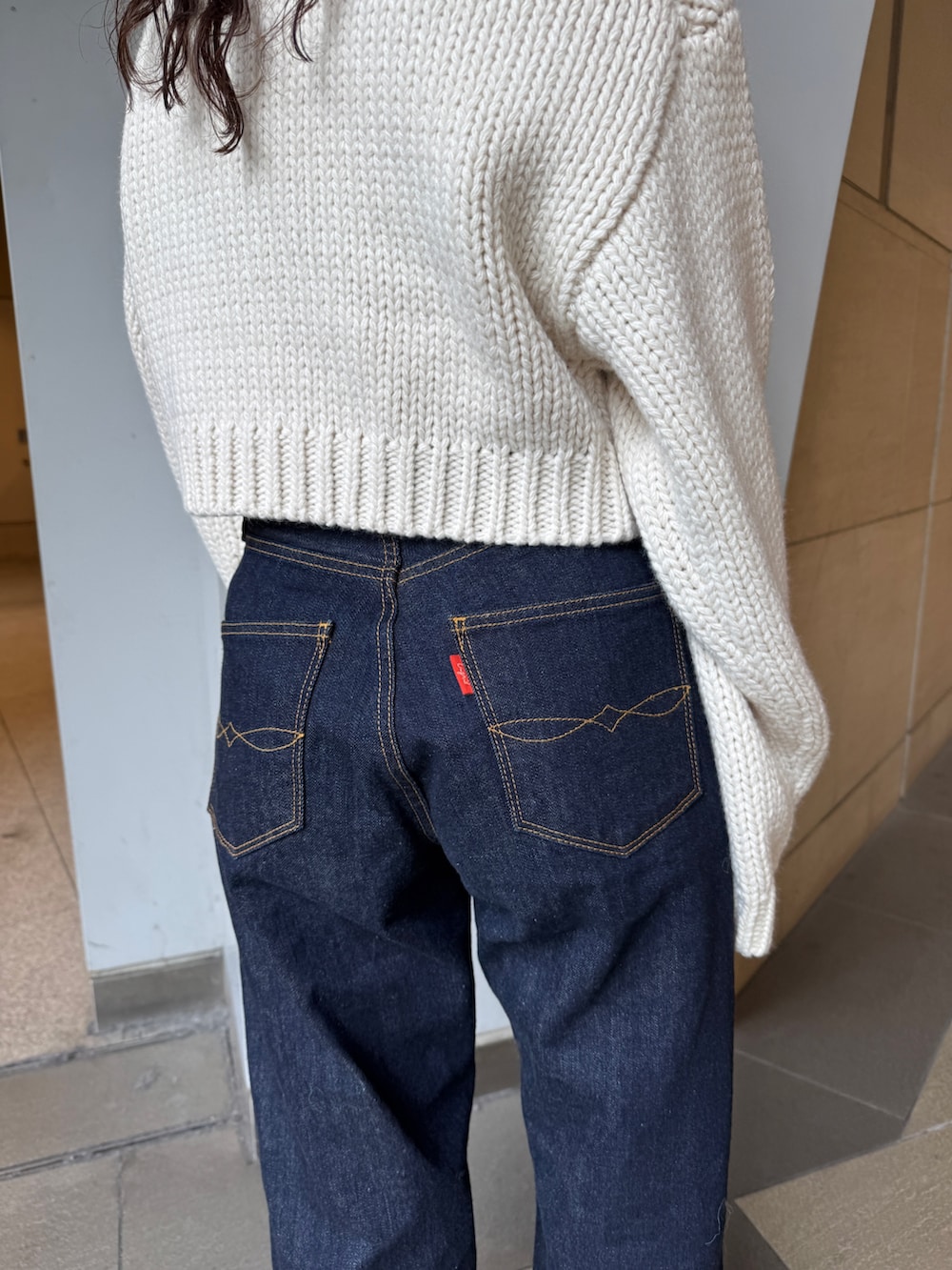 ホワイト系のTシャツ/カットソー、ホワイト系のカーディガン/ボレロ、ブルー系のデニムパンツを着用したレディースの冬コーディネートの7枚目の写真