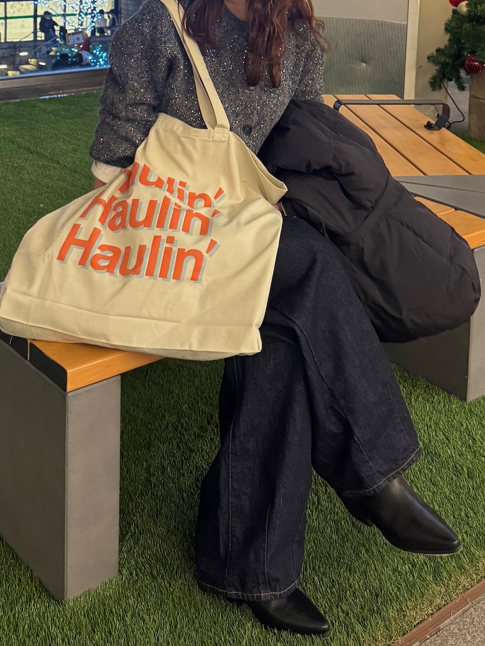 グレー系のカーディガン/ボレロ、ブラック系のダウンジャケット/コート、ホワイト系のトートバッグを着用したレディースの冬コーディネートの7枚目の写真