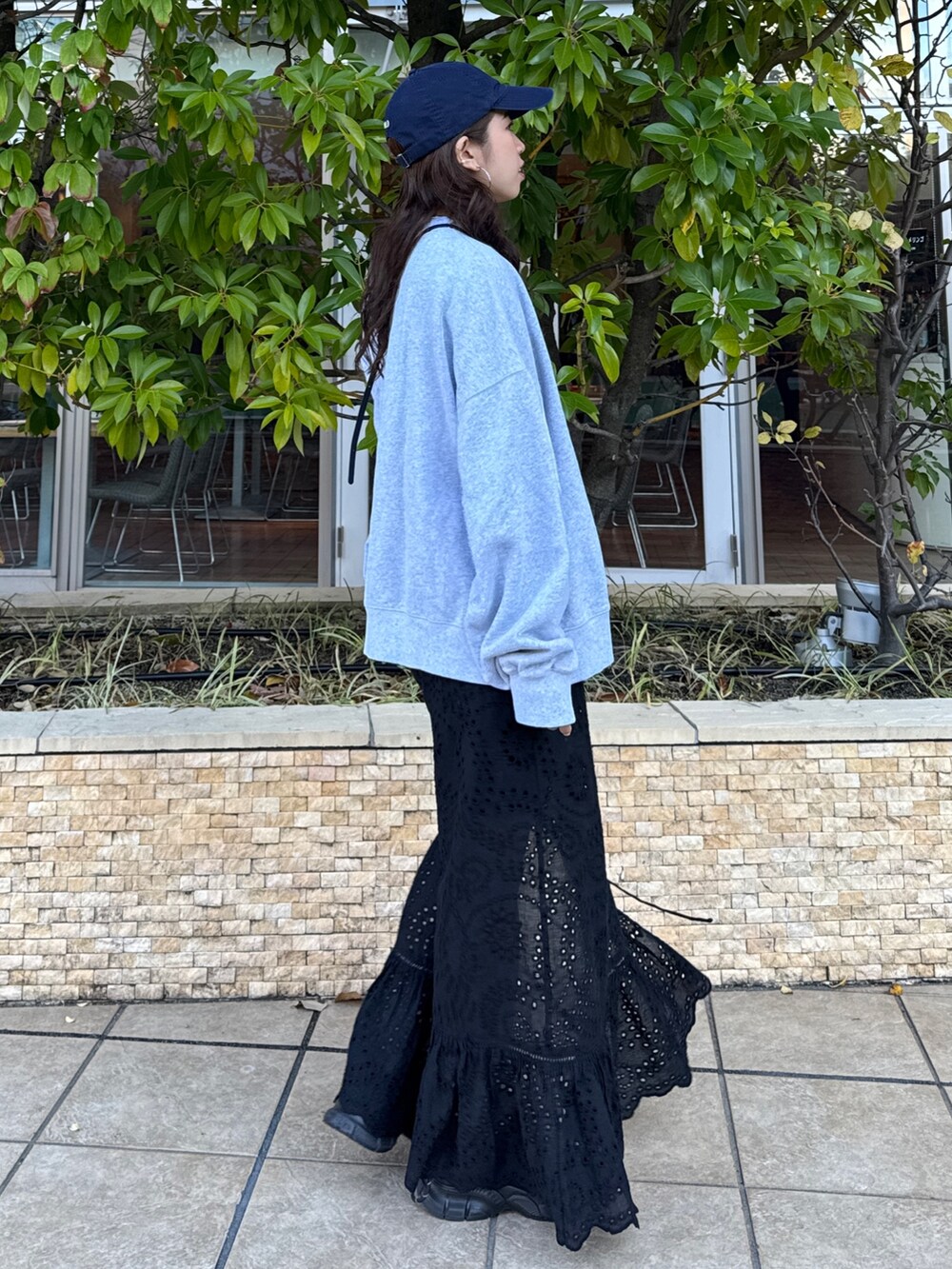 ブラック系のスカート、グレー系のスウェット、ブラック系のスニーカーを着用したレディースの冬コーディネートの4枚目の写真