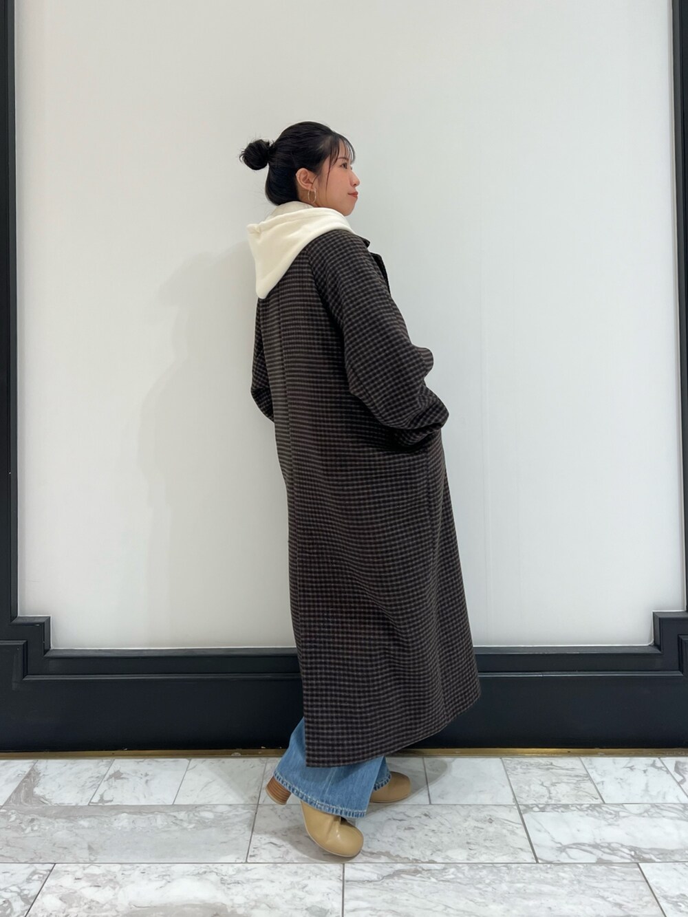 ベージュ系のブーツ、ブルー系のデニムパンツ、その他のチェスターコートを着用したレディースの冬コーディネートの5枚目の写真