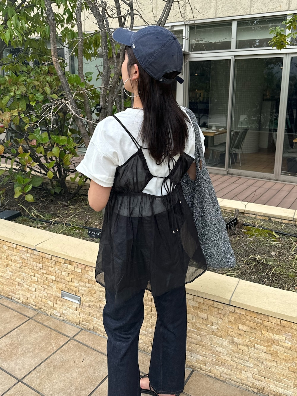 ブルー系のデニムパンツ、ホワイト系のTシャツ/カットソー、ブラック系のキャミソールを着用したレディースの春コーディネートの8枚目の写真