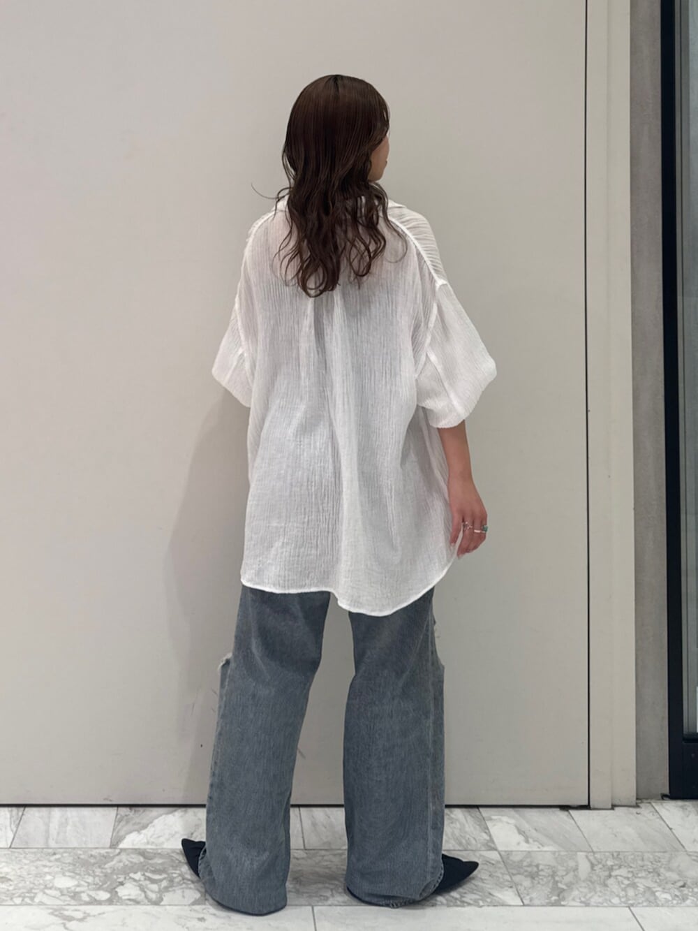 ブラック系のパンプス、ホワイト系のシャツ/ブラウス、ブルー系のデニムパンツを着用したレディースの春コーディネートの5枚目の写真