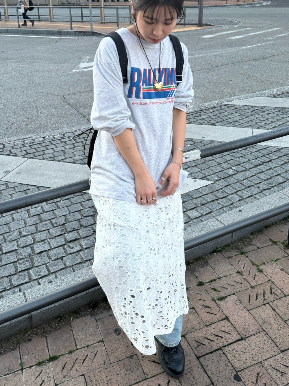 ブラック系のバックパック/リュック、ホワイト系のスカート、グレー系のTシャツ/カットソーを着用したレディースの冬コーディネートの9枚目の写真