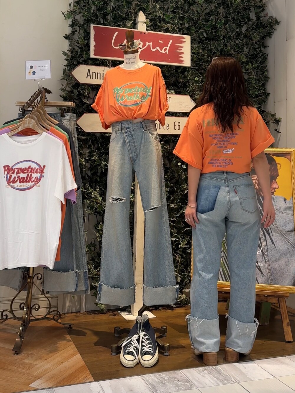 ブルー系のデニムパンツ、オレンジ系のTシャツ/カットソー、ホワイト系のサンダルを着用したレディースの夏コーディネートの3枚目の写真