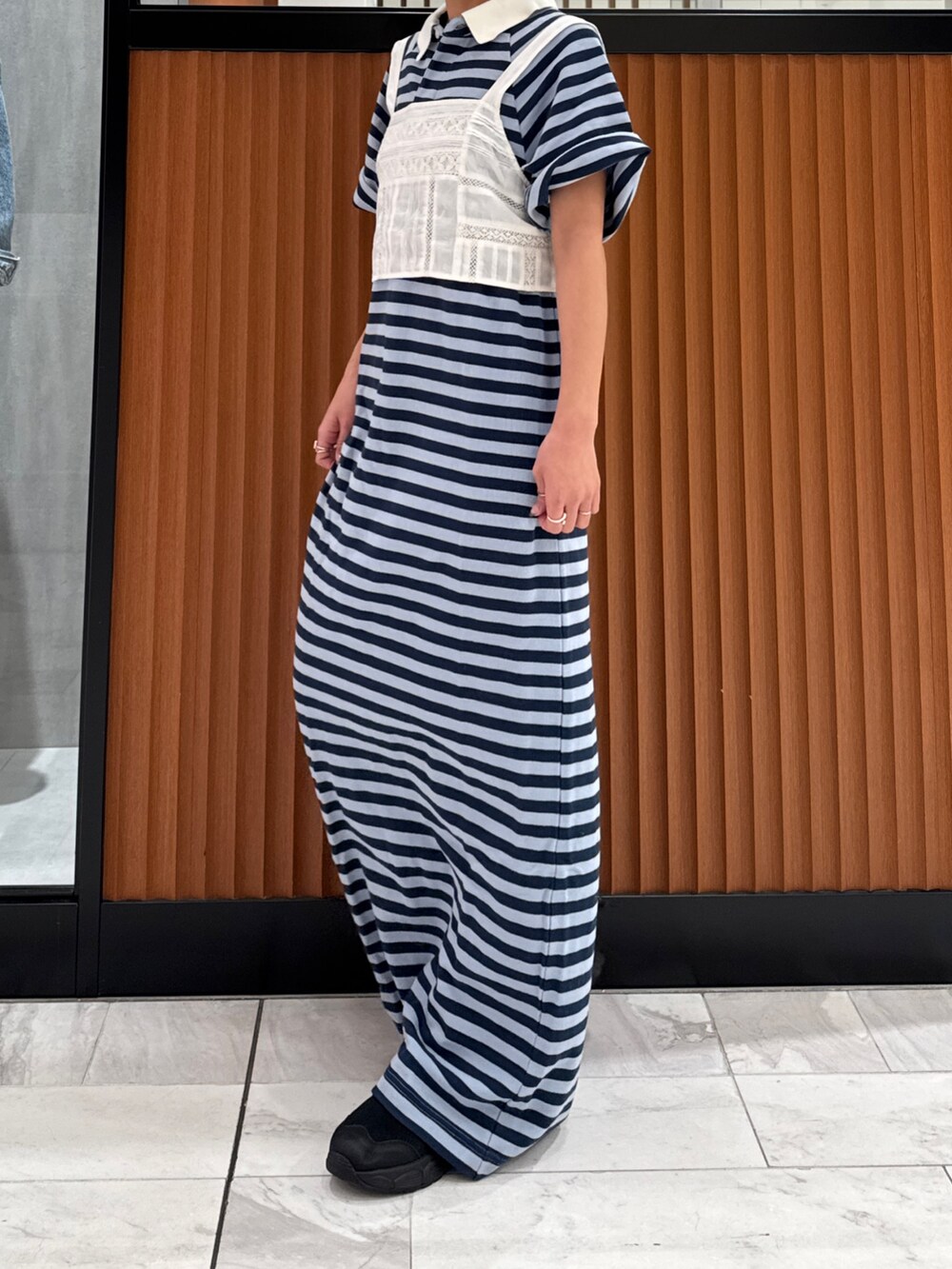 ホワイト系のキャミソール、ブルー系のワンピース、ブラック系のスニーカーを着用したレディースの春コーディネートの5枚目の写真