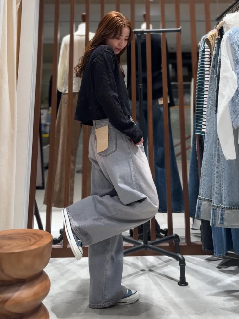 ブルー系のデニムパンツ、ブラック系のカーディガン/ボレロ、パープル系のTシャツ/カットソーを着用したレディースの春コーディネートの4枚目の写真