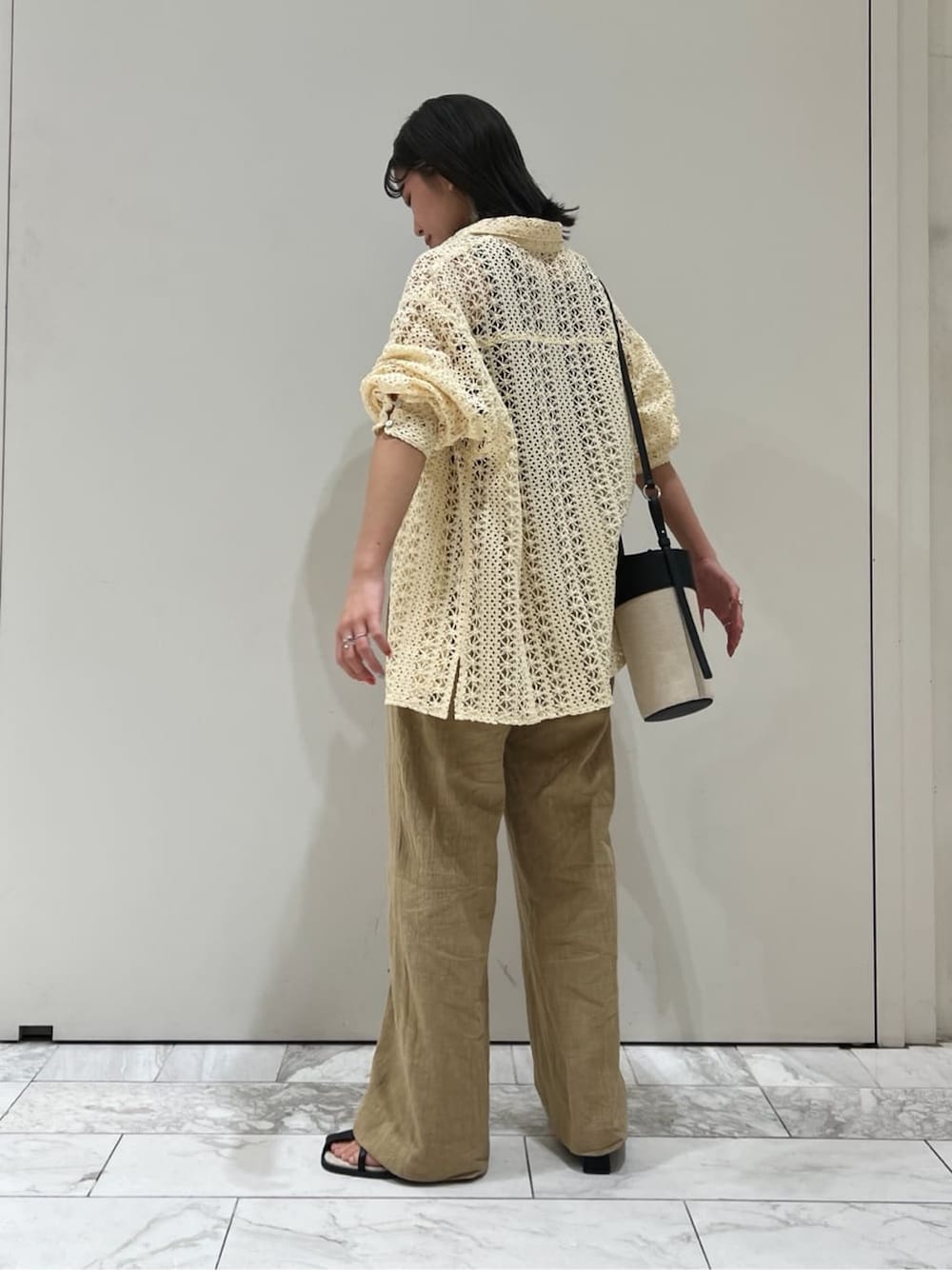 ブラック系のタンクトップ、ブラック系のサンダル、ブラック系のショルダーバッグを着用したレディースの春コーディネートの4枚目の写真