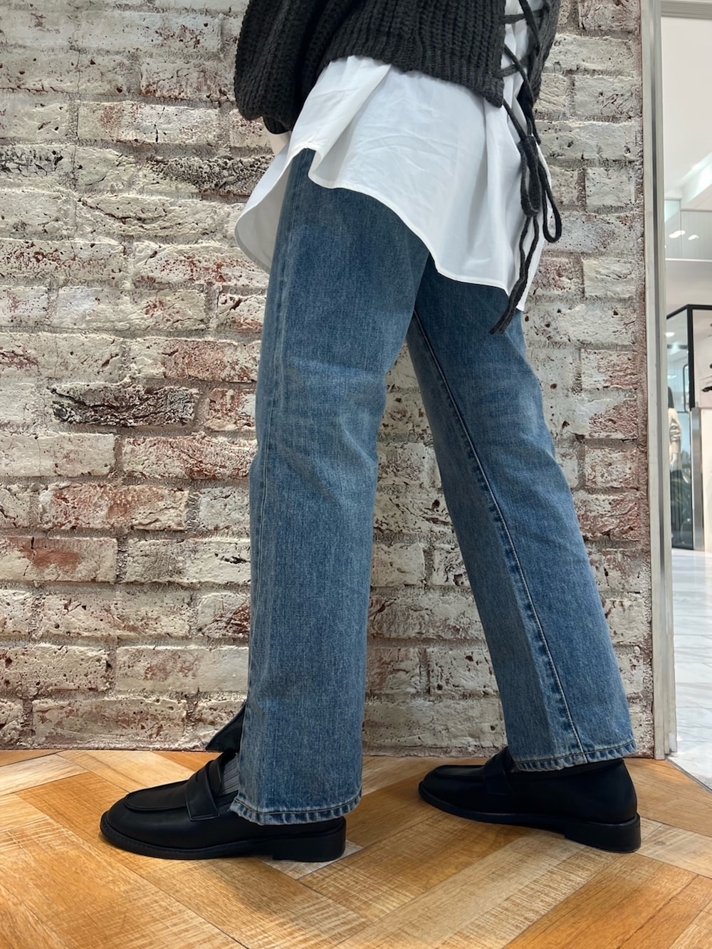 グレー系のニット/セーター、ブルー系のデニムパンツ、ブラック系のローファーを着用したレディースの秋コーディネートの9枚目の写真