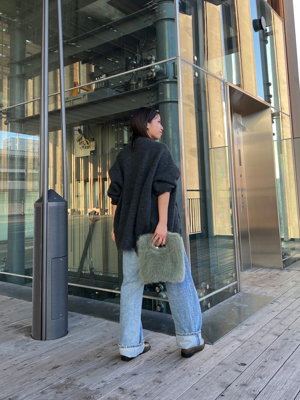 グレー系のカーディガン/ボレロ、ブラック系のキャミソール、ブルー系のデニムパンツを着用したレディースの秋コーディネートの4枚目の写真