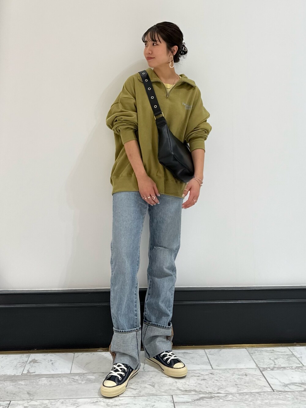 グリーン系のスウェット、ブラック系のショルダーバッグ、イエロー系のTシャツ/カットソーを着用したレディースの冬コーディネートの10枚目の写真