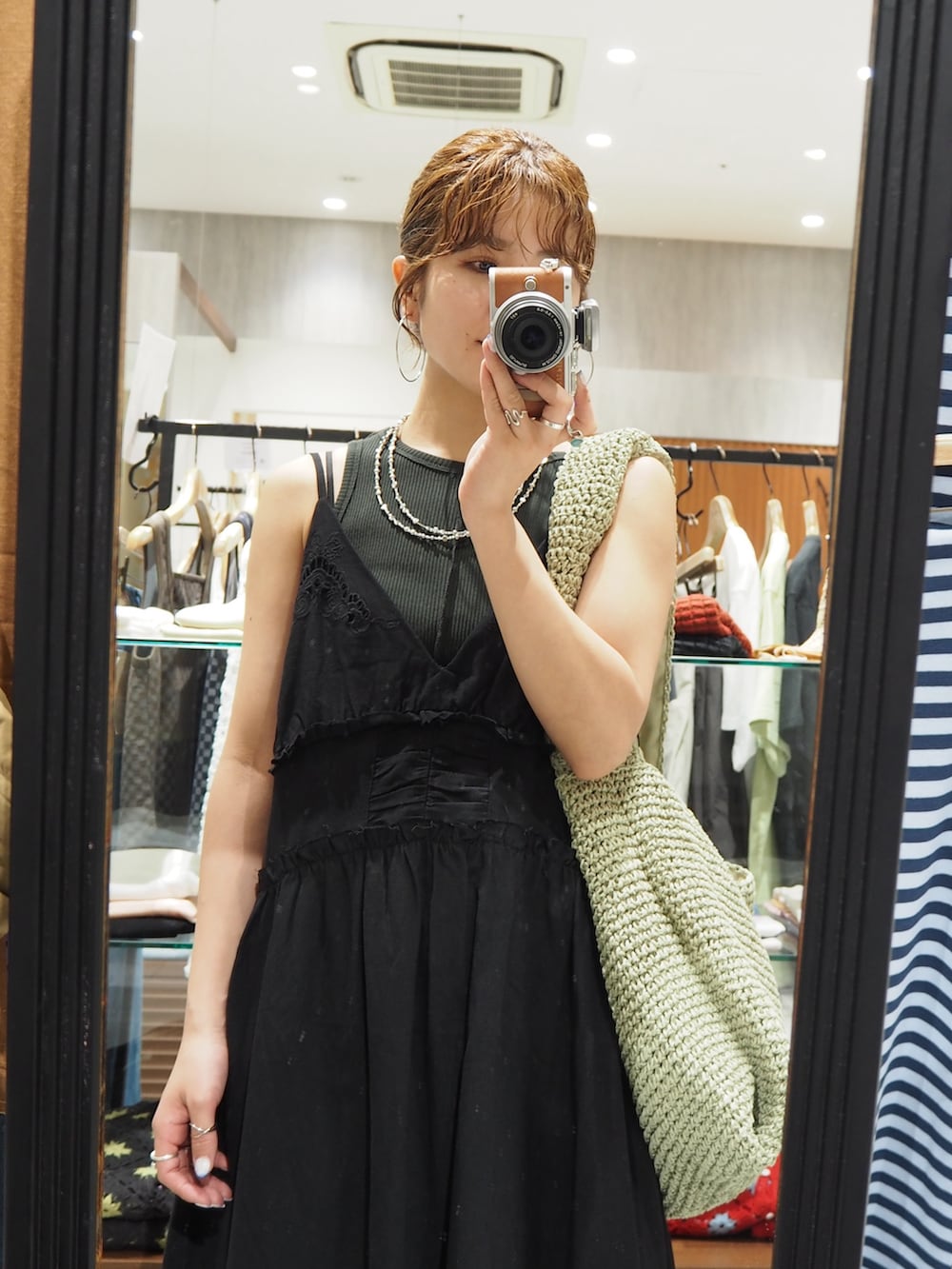 ブラック系のワンピース、グレー系のタンクトップ、ブルー系のデニムパンツを着用したレディースの春コーディネートの9枚目の写真