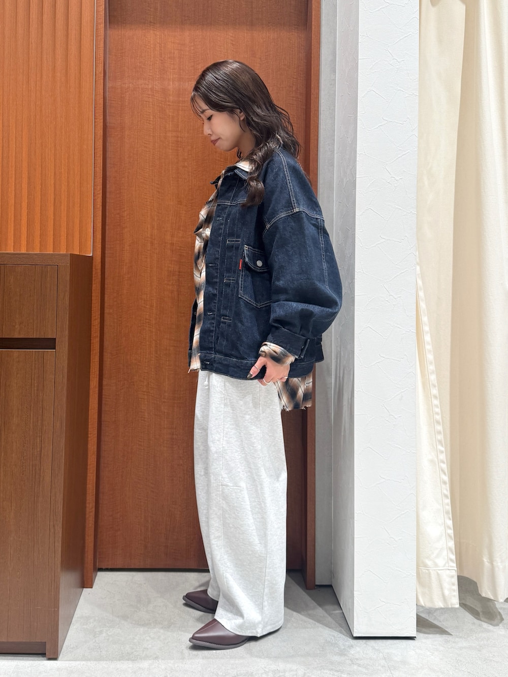 ブラウン系のシャツ/ブラウス、ブルー系のデニムジャケット、グレー系のスウェットパンツを着用したレディースの秋コーディネートの4枚目の写真