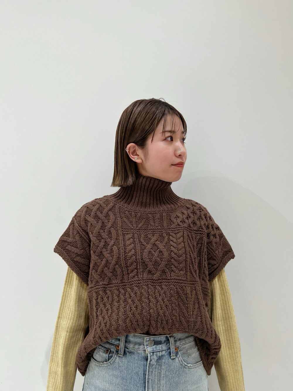 ブラウン系のニット/セーター、ブルー系のデニムパンツ、ブラック系のブーツを着用したレディースの冬コーディネートの7枚目の写真