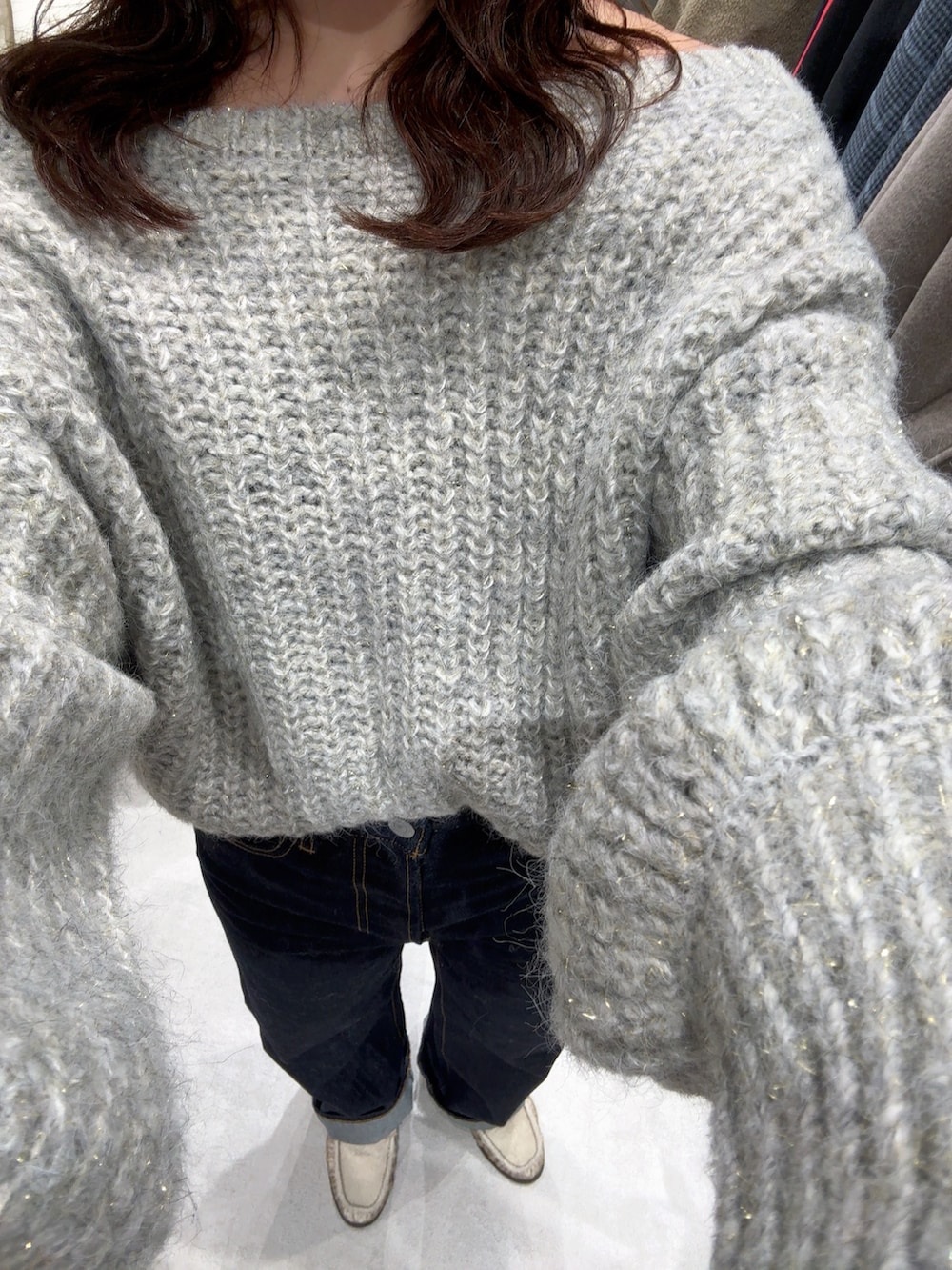 グレー系のニット/セーター、ブルー系のデニムパンツ、ホワイト系のハンドバッグを着用したレディースの冬コーディネートの9枚目の写真