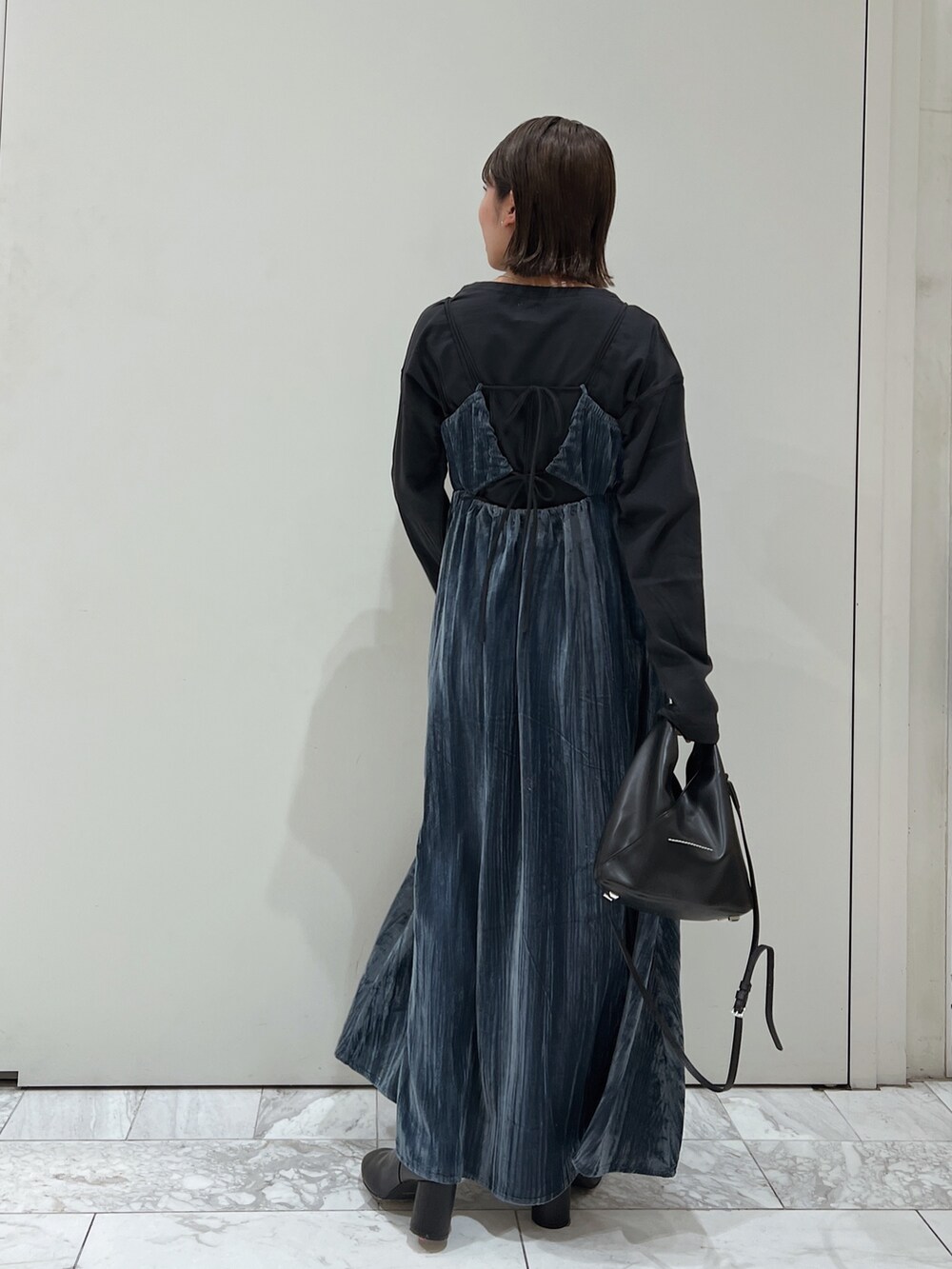 ブルー系のワンピース、ブラック系のTシャツ/カットソー、ブラック系のブーツを着用したレディースの冬コーディネートの6枚目の写真