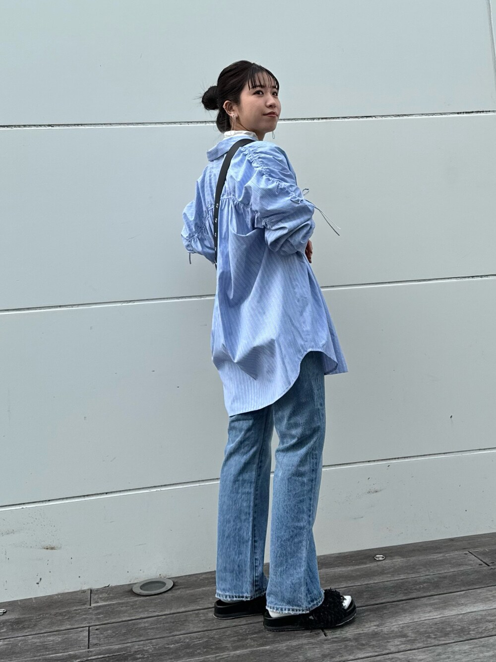 ホワイト系のTシャツ/カットソー、ブルー系のデニムパンツ、ブラック系のショルダーバッグを着用したレディースの冬コーディネートの3枚目の写真