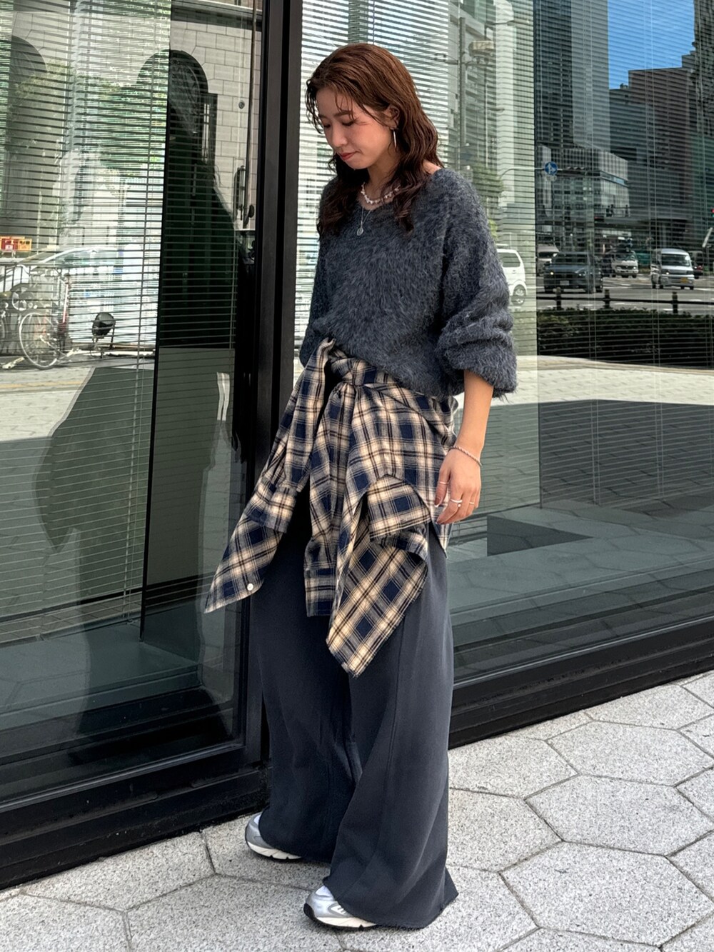 グレー系のスウェットパンツ、ブルー系のシャツ/ブラウス、グレー系のニット/セーターを着用したレディースの秋コーディネートの3枚目の写真