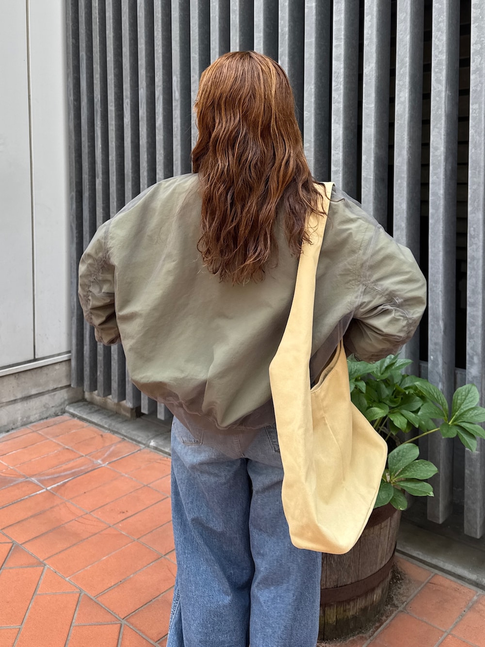 ベージュ系のトートバッグ、ホワイト系のタンクトップ、ブルー系のデニムパンツを着用したレディースの夏コーディネートの10枚目の写真