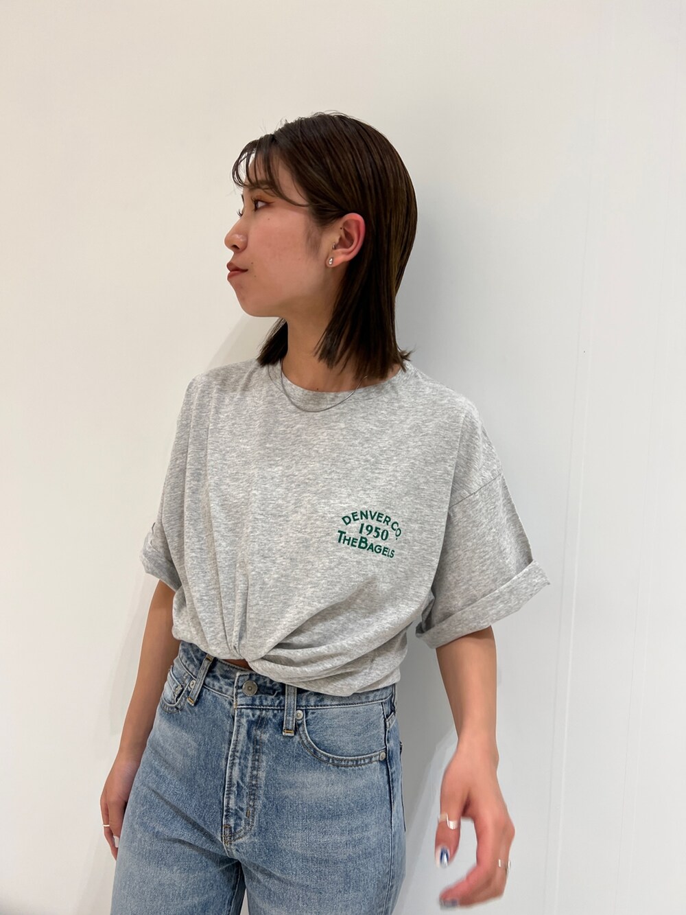 ブルー系のデニムパンツ、グレー系のTシャツ/カットソー、ホワイト系のスニーカーを着用したレディースの春コーディネートの8枚目の写真