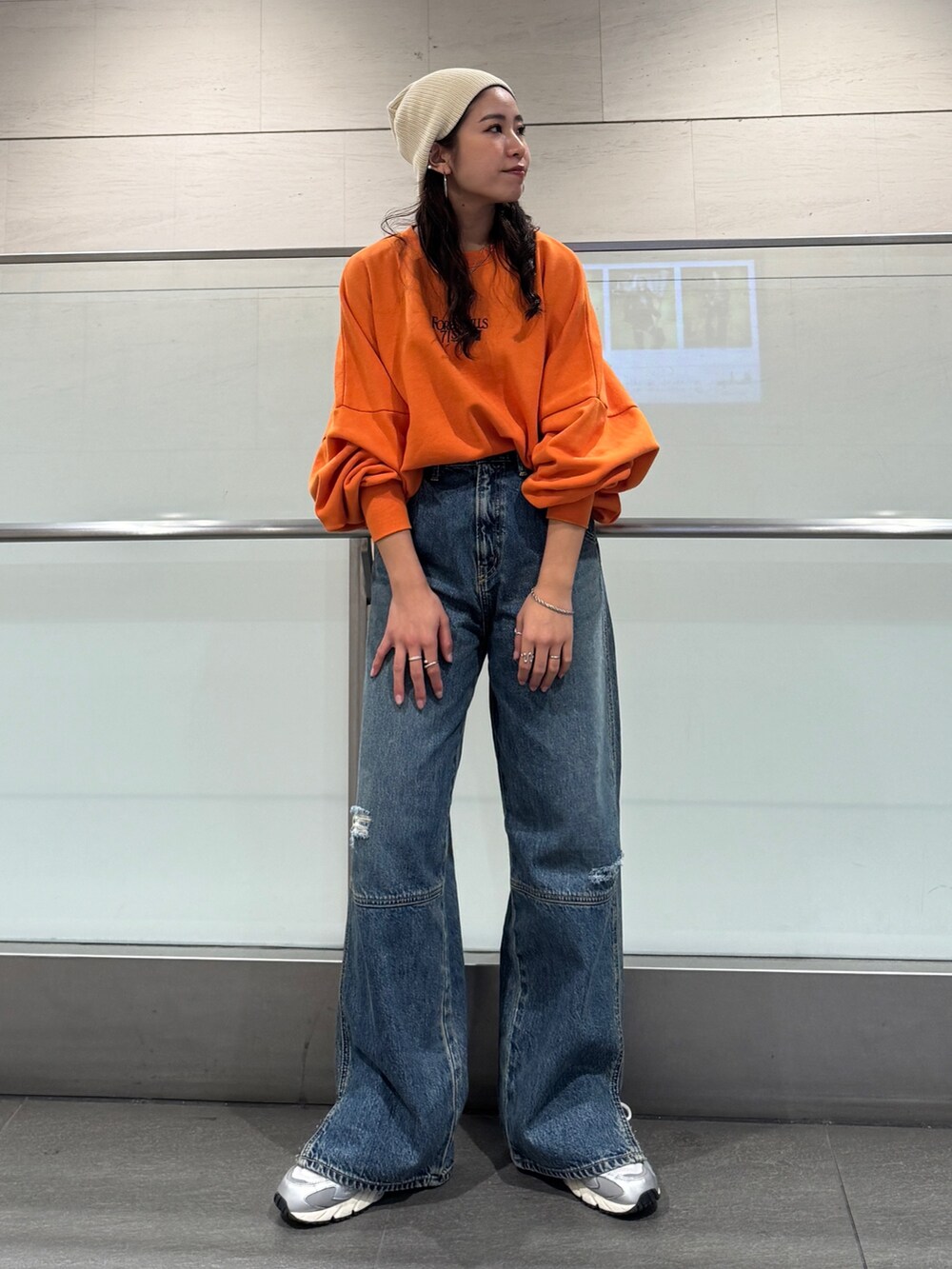 ブルー系のデニムパンツ、オレンジ系のスウェットを着用したレディースの冬コーディネートの2枚目の写真