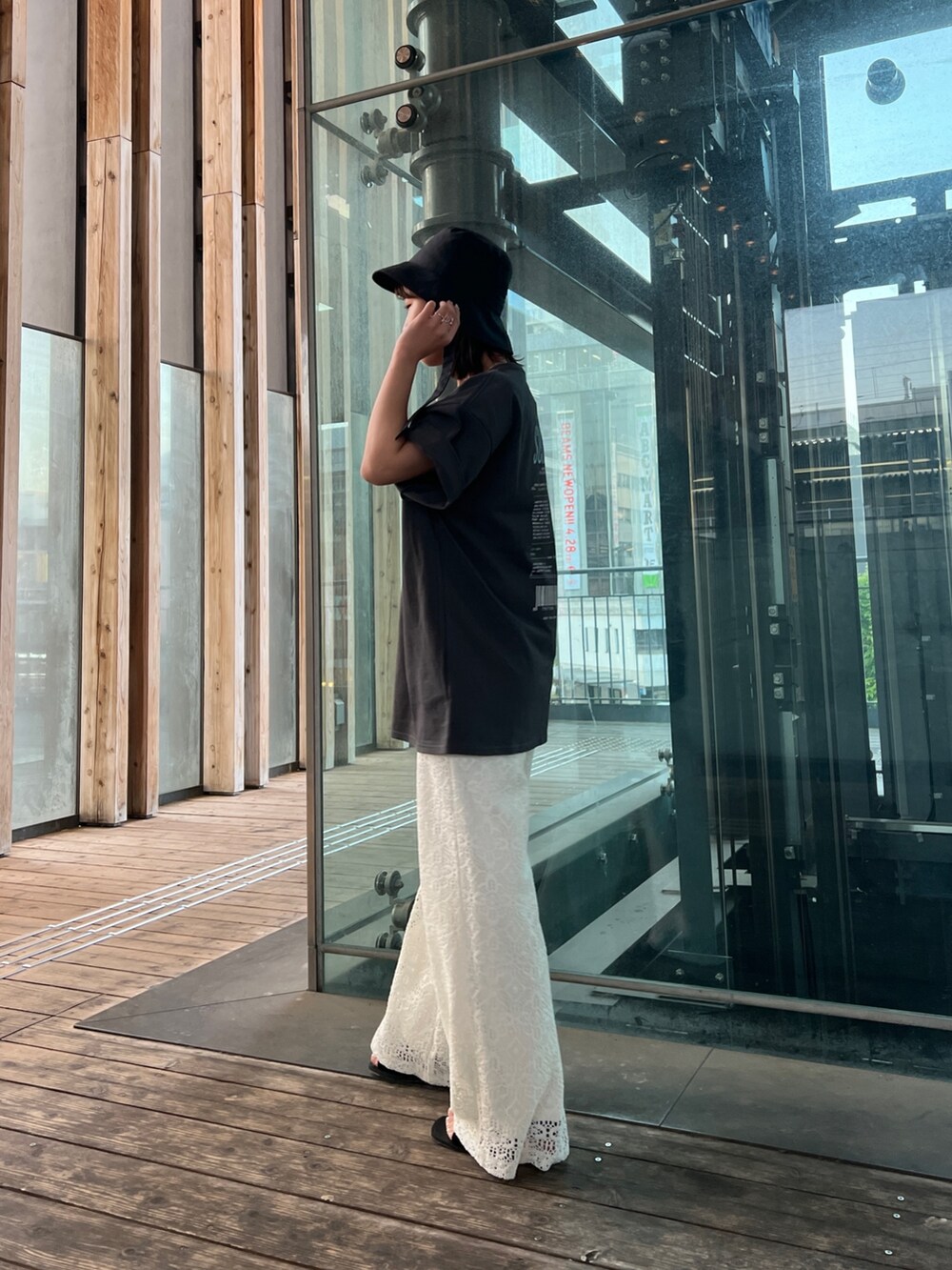 グレー系のTシャツ/カットソー、ホワイト系のその他パンツ、ブラック系のサンダルを着用したレディースの春コーディネートの3枚目の写真