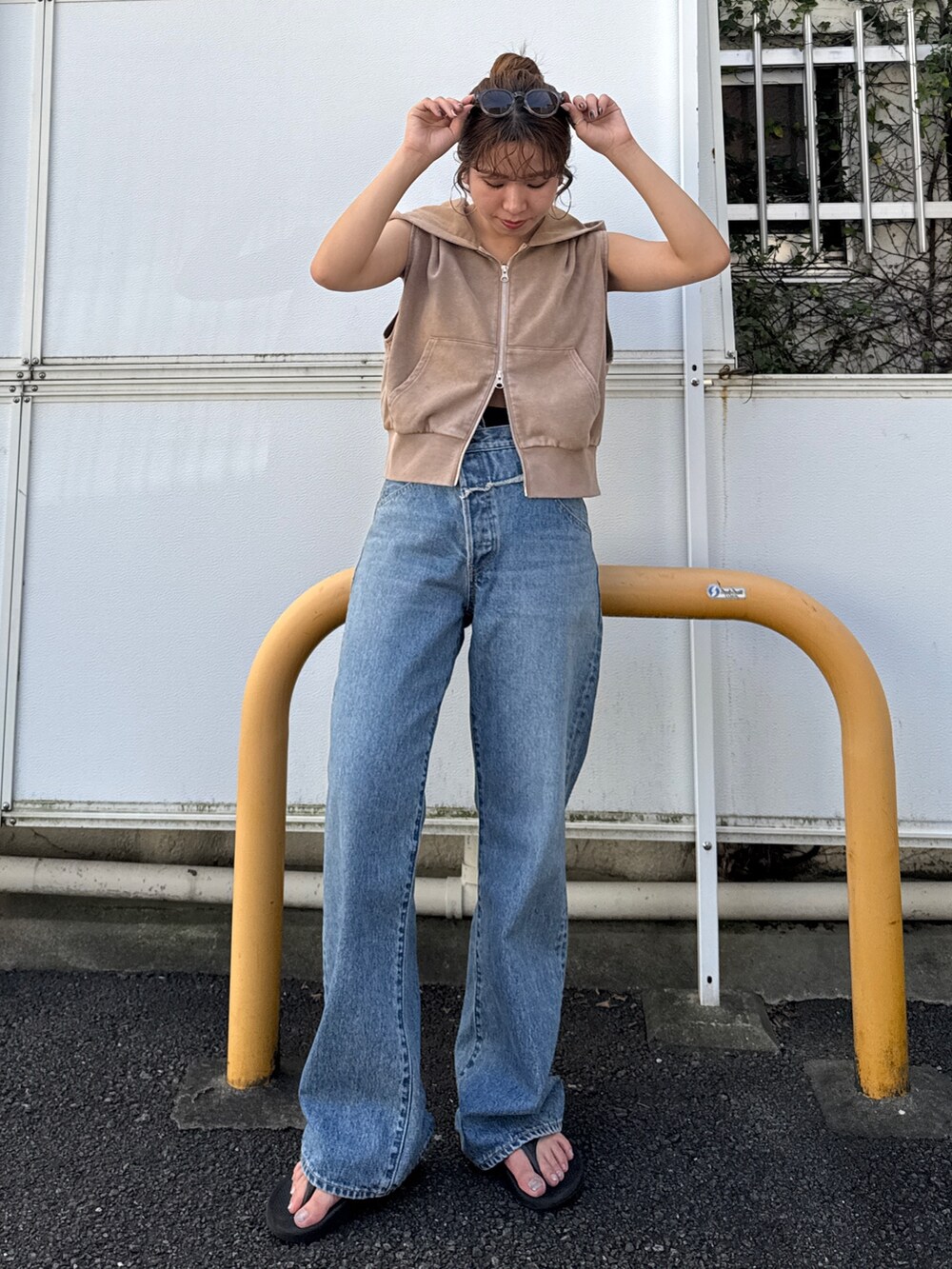 ベージュ系のパーカー、ブルー系のデニムパンツを着用したレディースの夏コーディネートの2枚目の写真