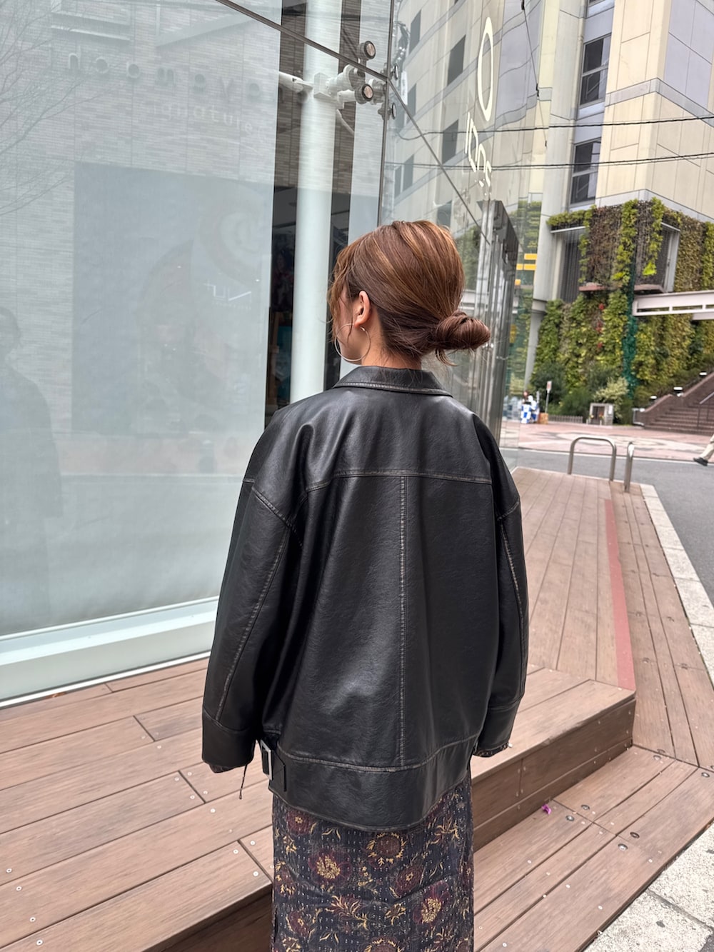 ブラック系のブルゾン、ブラック系のワンピース、ブルー系のデニムパンツを着用したレディースの冬コーディネートの9枚目の写真