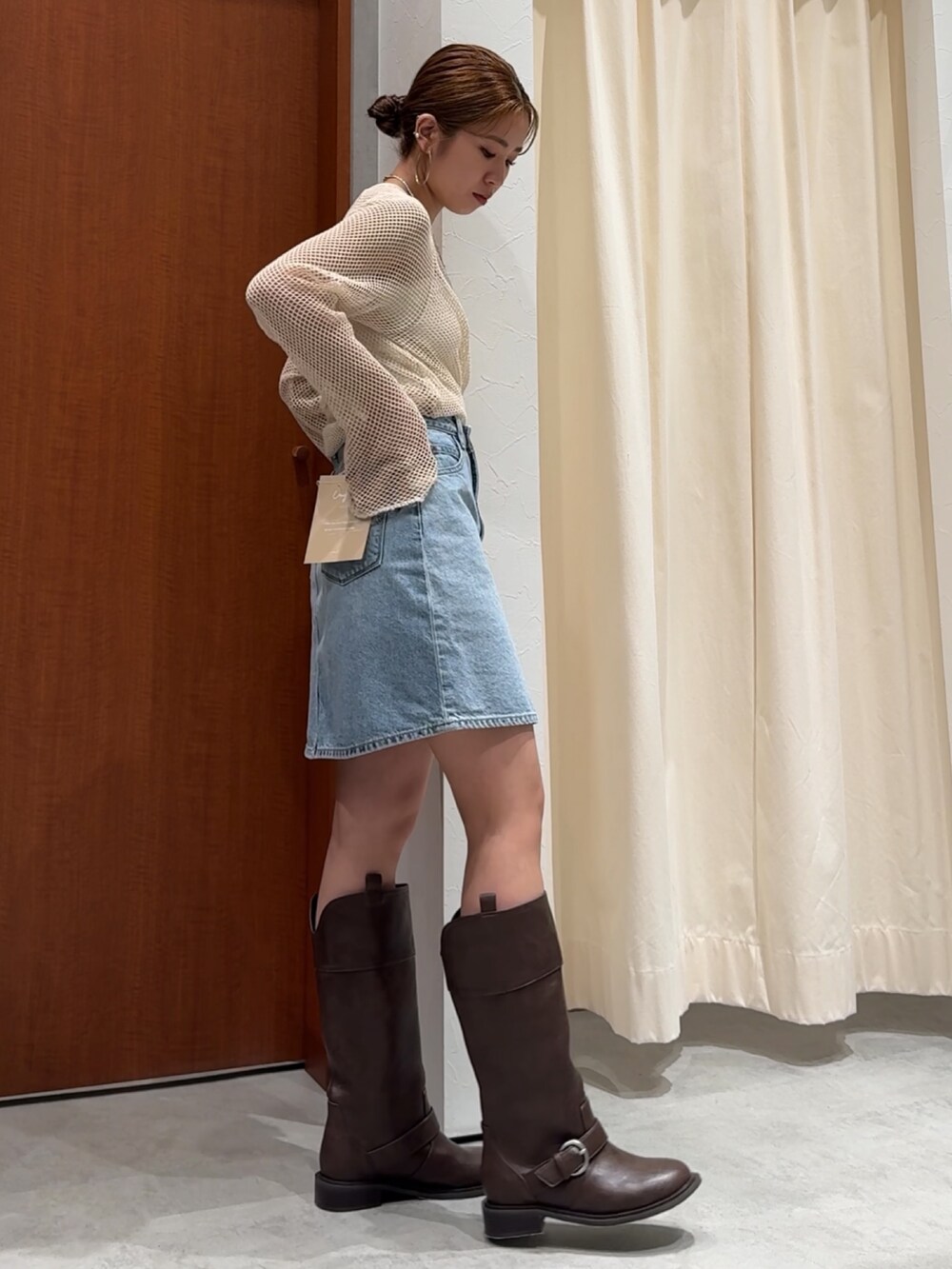 ホワイト系のTシャツ/カットソー、ブルー系のスカート、ブラウン系のブーツを着用したレディースの春コーディネートの6枚目の写真