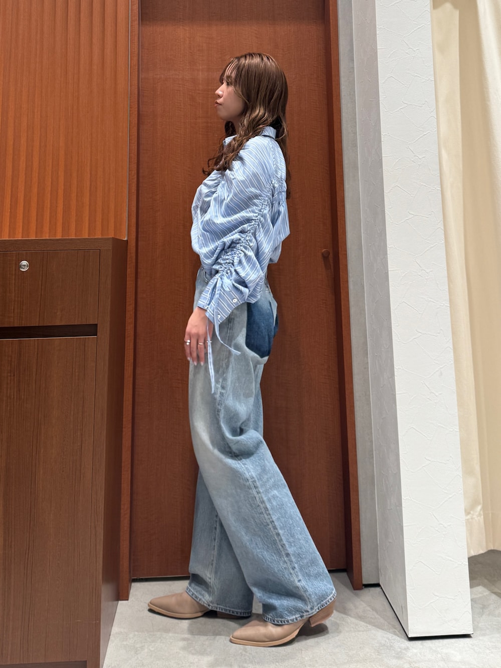 ブルー系のシャツ/ブラウス、ブルー系のデニムパンツ、ベージュ系のブーツを着用したレディースの春コーディネートの6枚目の写真