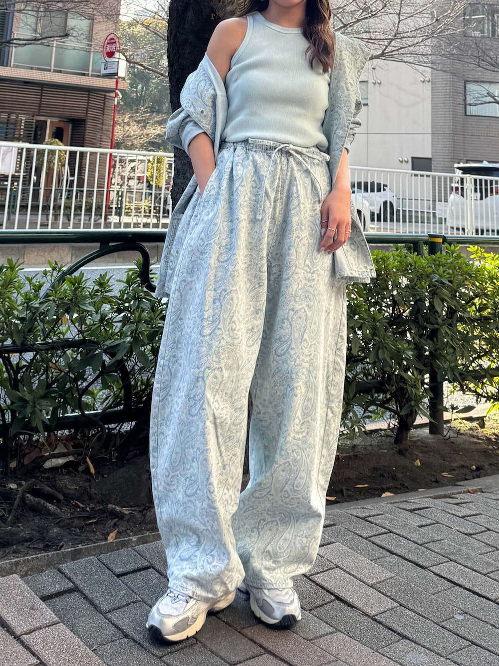 ブルー系のカバーオール、ブルー系のデニムパンツ、ブルー系のタンクトップを着用したレディースの春コーディネートの2枚目の写真