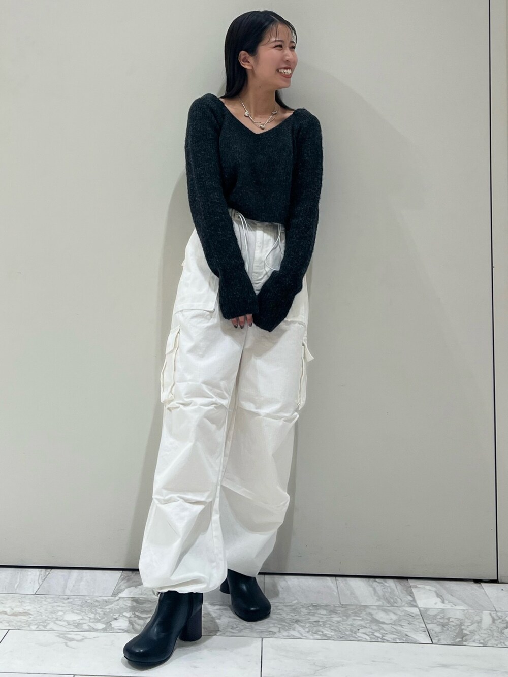 ブラック系のブーツ、ホワイト系のカーゴパンツ、グレー系のニット/セーターを着用したレディースの秋コーディネートの6枚目の写真