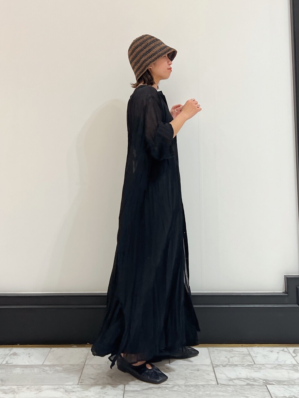 ブラック系のワンピース、ブラック系のパンプス、ブラック系のスカートを着用したレディースの春コーディネートの2枚目の写真