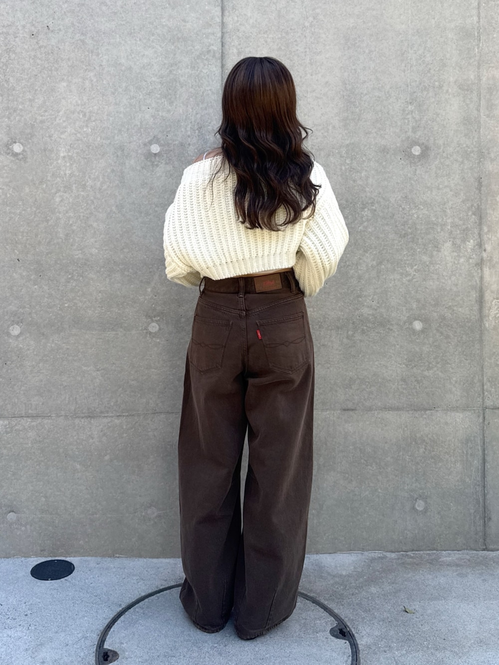 ブラック系のその他シューズ、ブラウン系のデニムパンツ、ホワイト系のニット/セーターを着用したレディースの秋コーディネートの3枚目の写真
