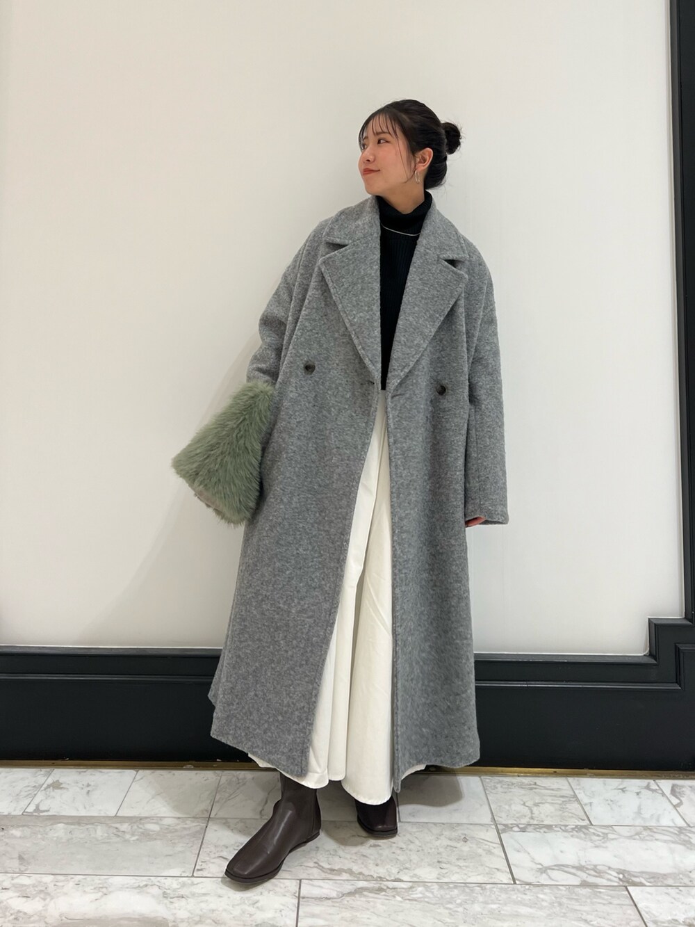 ブラウン系のブーツ、ブラック系のワンピース、グレー系のチェスターコートを着用したレディースの冬コーディネートの5枚目の写真