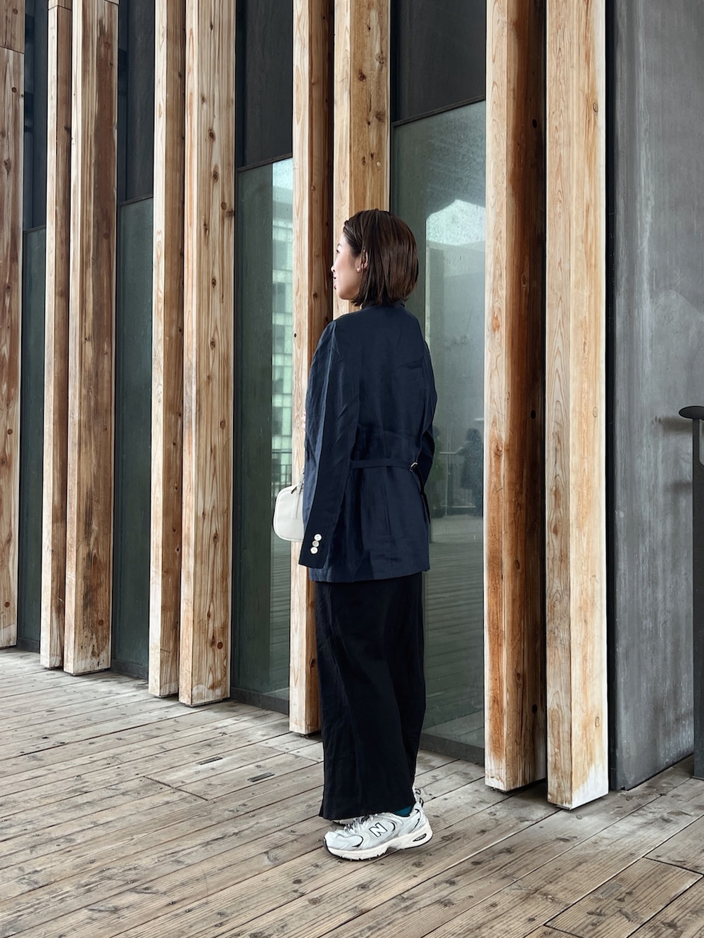 ブルー系のテーラードジャケット、ブラック系のスカート、ホワイト系のTシャツ/カットソーを着用したレディースの春コーディネートの2枚目の写真