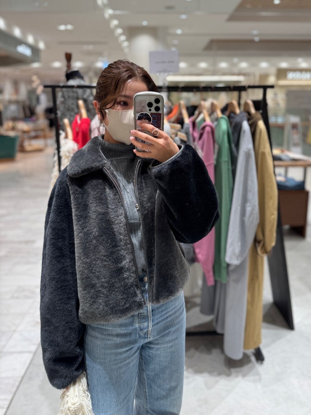 グレー系のブルゾン、グレー系のニット/セーター、ブルー系のデニムパンツを着用したレディースの秋コーディネートの7枚目の写真