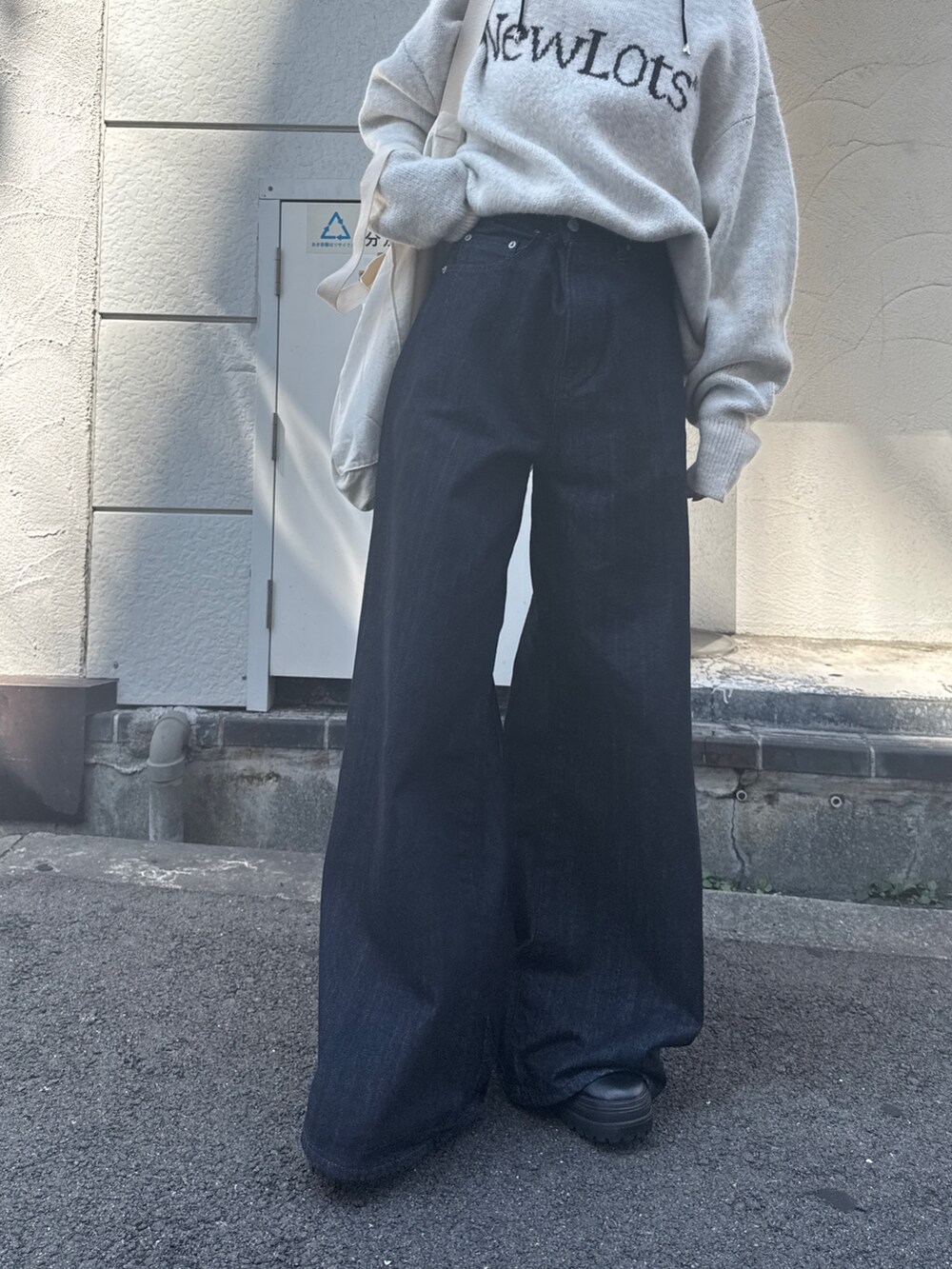 ブルー系のデニムパンツ、ホワイト系のニット/セーター、ホワイト系のトートバッグを着用したレディースの夏コーディネートの9枚目の写真