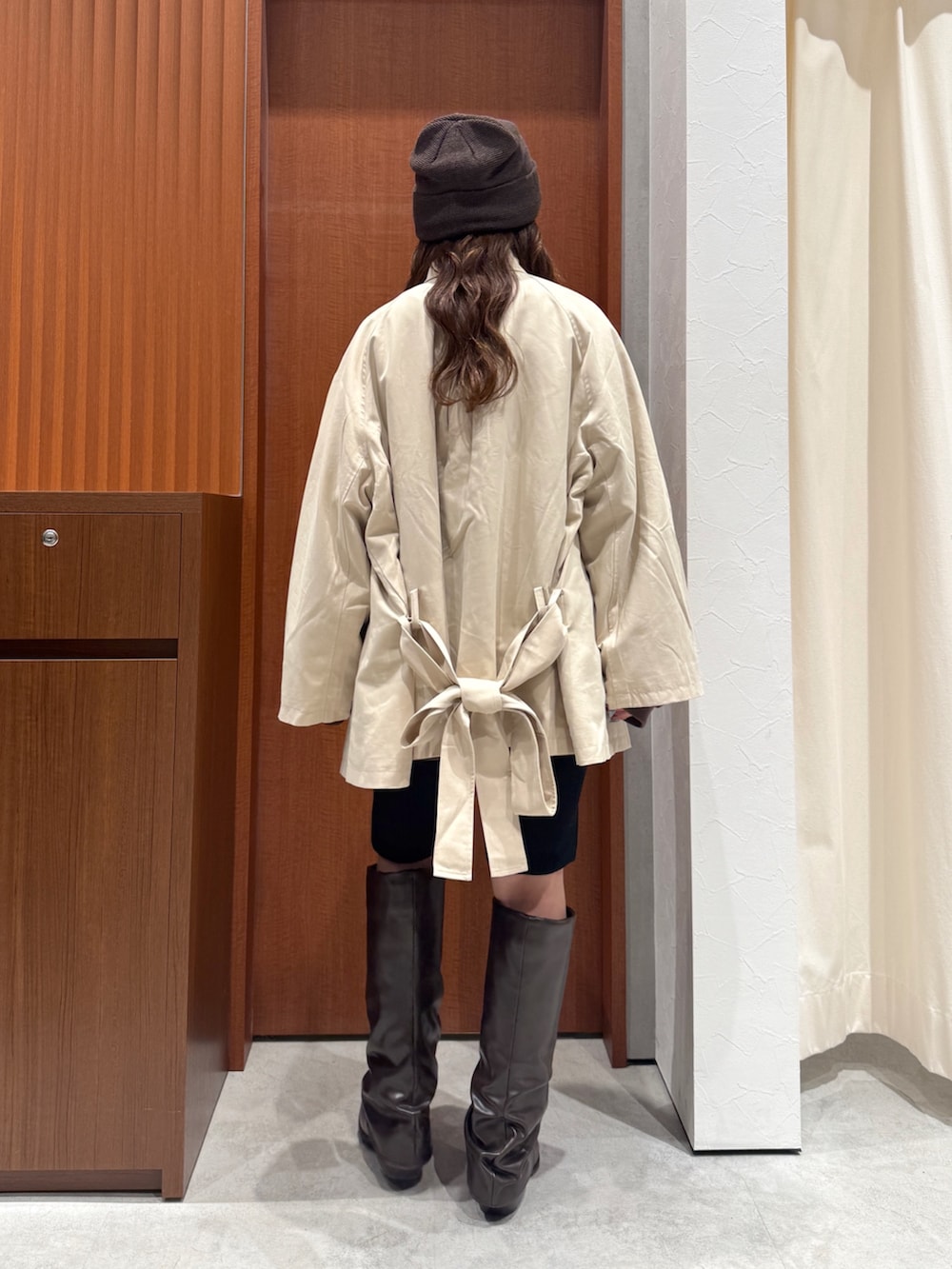 ベージュ系のトレンチコート、ブラウン系のスウェット、ブラック系のその他パンツを着用したレディースの秋コーディネートの3枚目の写真