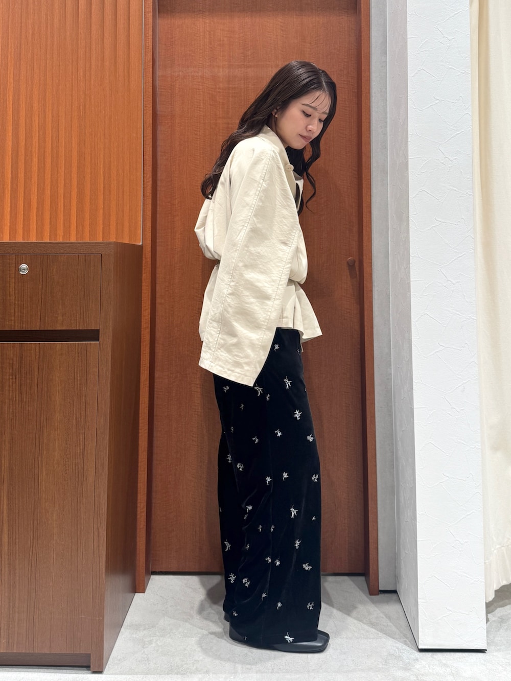 ブラック系のその他パンツ、ベージュ系のトレンチコート、ブラック系のサンダルを着用したレディースの秋コーディネートの3枚目の写真