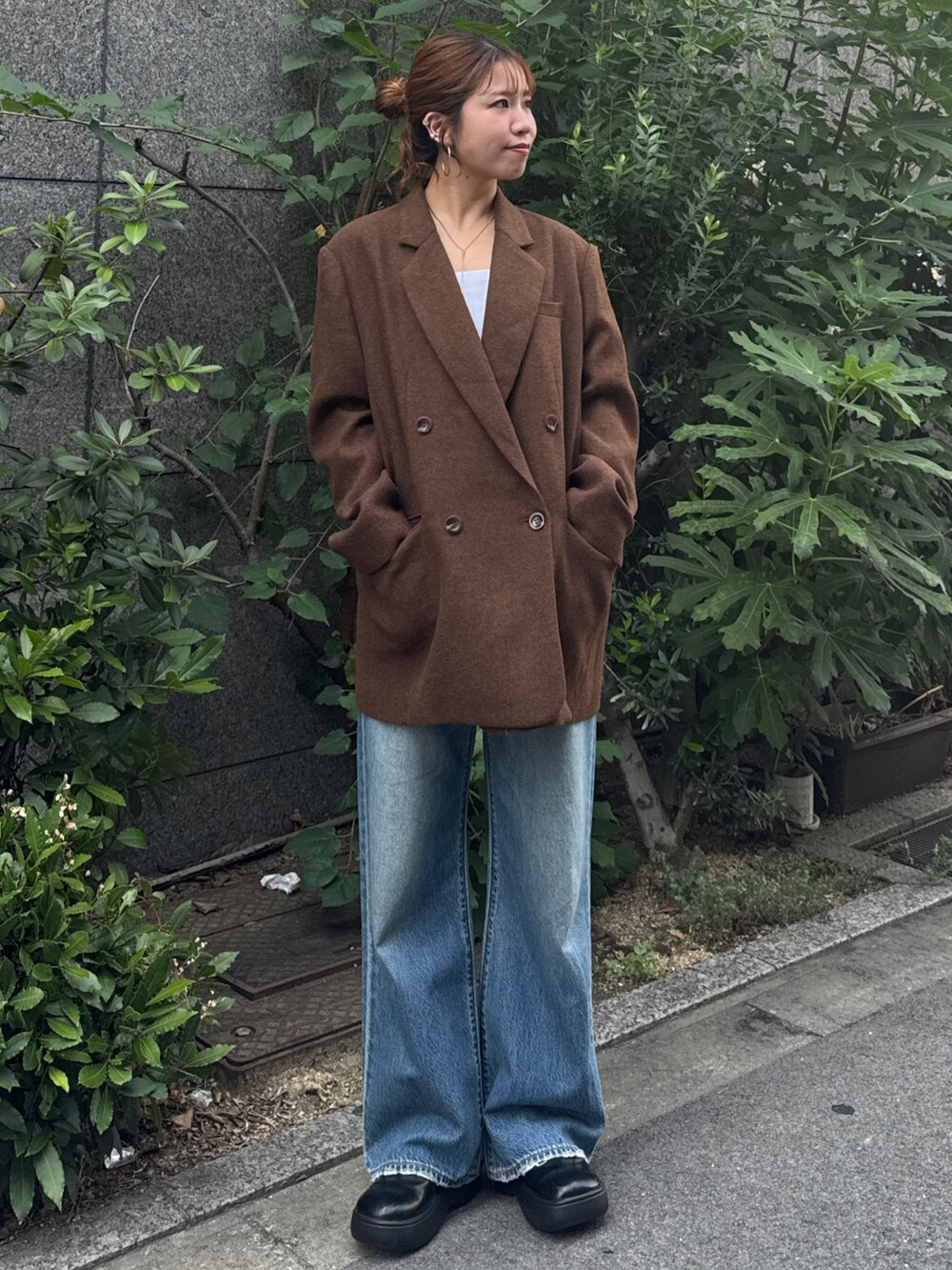 ブラウン系のテーラードジャケット、ブルー系のデニムパンツを着用したレディースの秋コーディネートの2枚目の写真