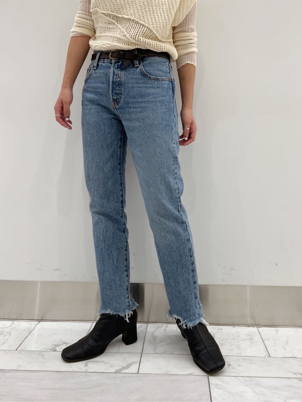 ブラック系のブーツ、ホワイト系のニット/セーター、ホワイト系のニット/セーターを着用したレディースの夏コーディネートの2枚目の写真